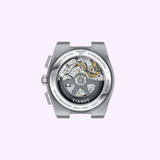 A close-up of the back of the Tissot Watches PRX 42mm T1374271104101 showcases its exposed mechanical movement, stainless steel case, and engraved details under a scratch-resistant sapphire crystal on a light purple background.