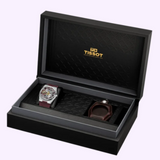 Open black presentation box containing a Tissot Watches PRX T1374051737100 Skeleton Damian Lillard Special Edition watch with a maroon strap and a matching leather accessory case.