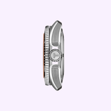 Side view of the Tissot Watches Seastar 2000 44mm T1209071728100, a silver Swiss automatic watch with a textured bezel, prominent crown, and minimalist design, displayed on a light purple background.