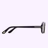 A side view of the Tom Ford Sunglasses FT1364/s 4901A in black, featuring gold accents on the temple and tip, set against a light purple background, captures an air of Miami sophistication.