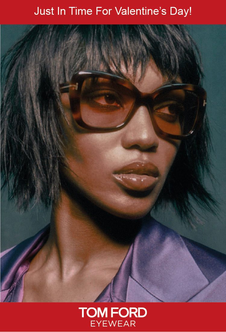 A person wearing large brown sunglasses and a shiny purple jacket stares off-camera against a dark background. The text reads, “Just In Time For Valentine’s Day!” at the top and “Tom Ford Eyewear” at the bottom.
