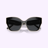 Front view of Tory Burch Sunglasses 0TY7184U 17281354 in black, featuring an oversized butterfly shape with a subtle gold trim along the edges, set against a light purple background. The brand name Tory Burch Sunglasses is visible on the inside of the left lens, emphasizing these sunglasses as a stylish accessory with essential UV protection.