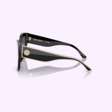 The Tory Burch Sunglasses 0TY7184U 17281354 feature black frames with thick, glossy arms, gold trim, and the signature Tory Burch logo on the temple for a stylish look and reliable UV protection, showcased against a light purple background.