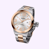 A TW Steel Watches CB121 45mm men’s automatic watch from the New Canteen Collection, featuring a silver-tone dial with bold numerals, date display, and a two-tone stainless steel bracelet, is showcased against a light pink background.