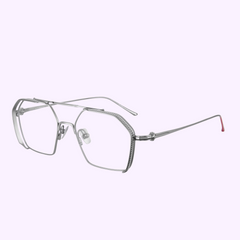 The Vysen Sunglasses The Koyv KV3 unisex prescription glasses feature thin silver titanium geometric frames, clear lenses, and a subtle red tip on the right temple. Handcrafted in Italy, they are shown against a light purple background. UPC: 3423104182965.