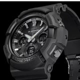 A close-up of the CASIO G-Shock Watch ANALOG-DIGITAL GAS100B-1A by G-Shock Watches, showcasing its black rugged and durable design, labeled buttons, and combination of analog and digital displays with multiple dials and indicators on the Tough Solar watch face.