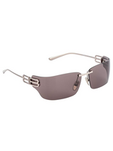 The Balenciaga Sunglasses BB0485SA-002 76 feature a rimless design with brown-tinted lenses, thin metal arms, and silver accents near the hinges, offering a luxurious designer look.