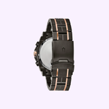 The Bulova 98D149 Precisionist men's watch by Bulova Watches features a black/rose gold metal band and case, black patterned dial, luminous hands, date display, 300m water resistance—all set on a light pink background.