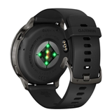 Back view of a Garmin Watches Venu® 4 – 45 mm 010-03014-00 smartwatch with a black silicone band, showing the heart rate sensor with glowing green lights and metal charging pins.