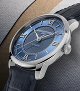 The Frederique Constant Classics Premiere FC-301N3B6 features a textured blue dial, silver Roman numerals, and a black leather strap, set against neutral layered paper backgrounds.