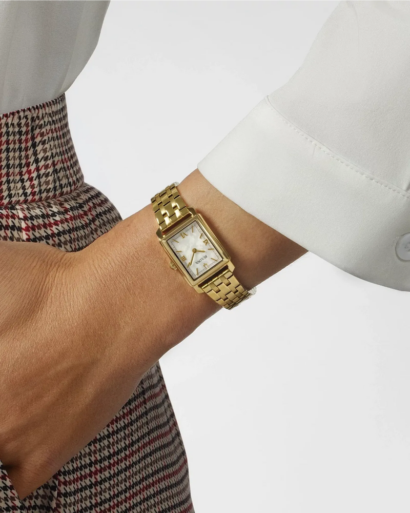 Woman wearing the Bulova Sutton 97L177 gold-tone watch with a white long-sleeve shirt