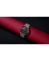 A Bulova 98B451 men's chronograph from Bulova Watches, featuring a gold and silver stainless steel band, black and red bezel, and black dial, is displayed on a red cylinder against a black background.