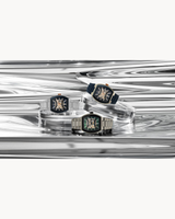 Three luxury wristwatches, including the Bulova Maquina 98A318 from Bulova Watches and a rose gold stainless steel men's automatic skeleton watch, are displayed on transparent stands against a wavy metallic silver background.