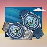 Two vibrant Mido Watches SPECIAL EDITION OCEAN STAR DECOMPRESSION WORLDTIMER M026.829.17.041.00 men’s watches, one with a metal mesh strap and one with a blue patterned extra strap, are shown against waves, a gradient sky, and clouds.