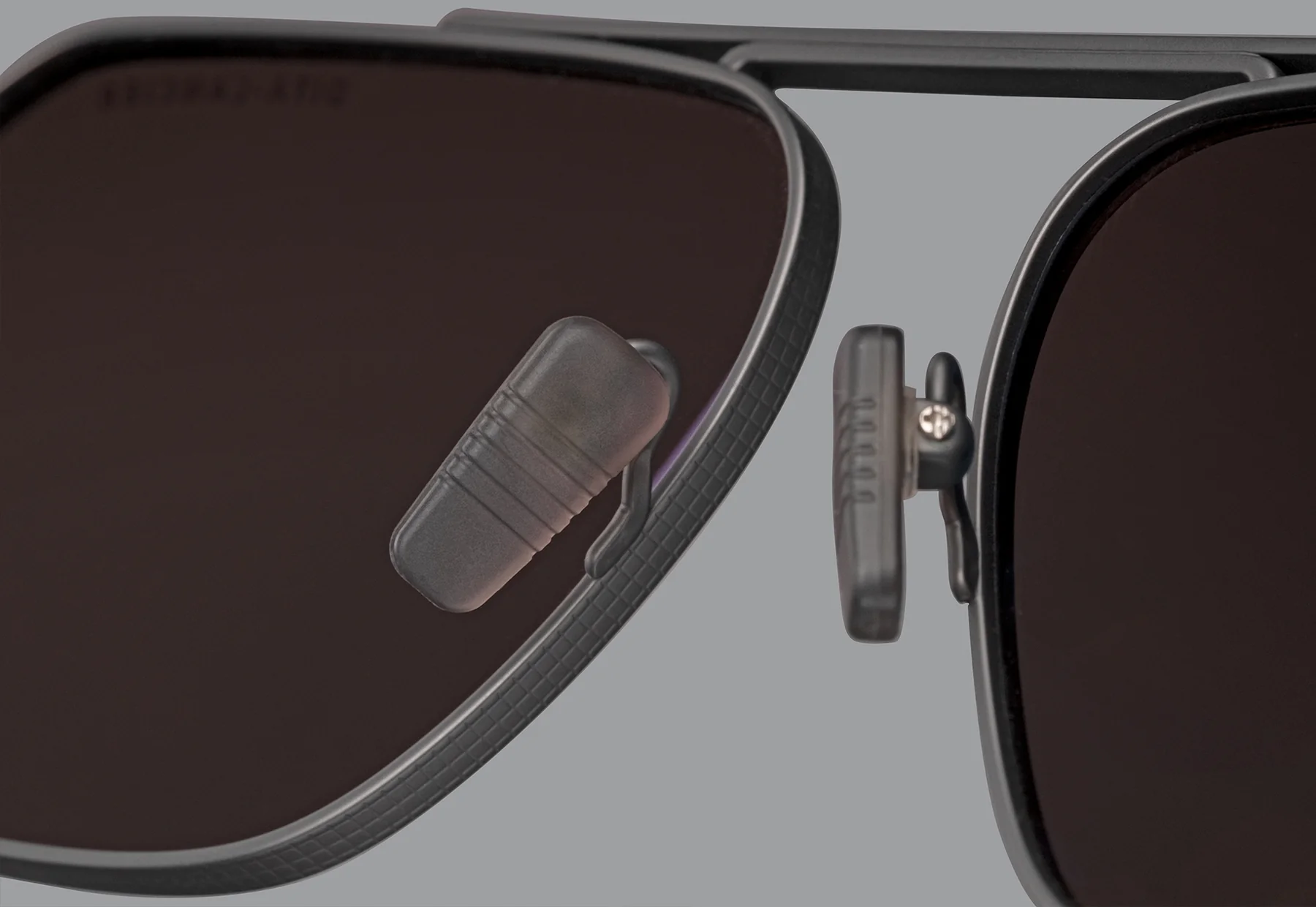 Close-up of the nose pads and polarized lenses on Dita Sunglasses DLS424-A-03 LSA-424, featuring a matte frame and dark lenses, set against a plain gray background.