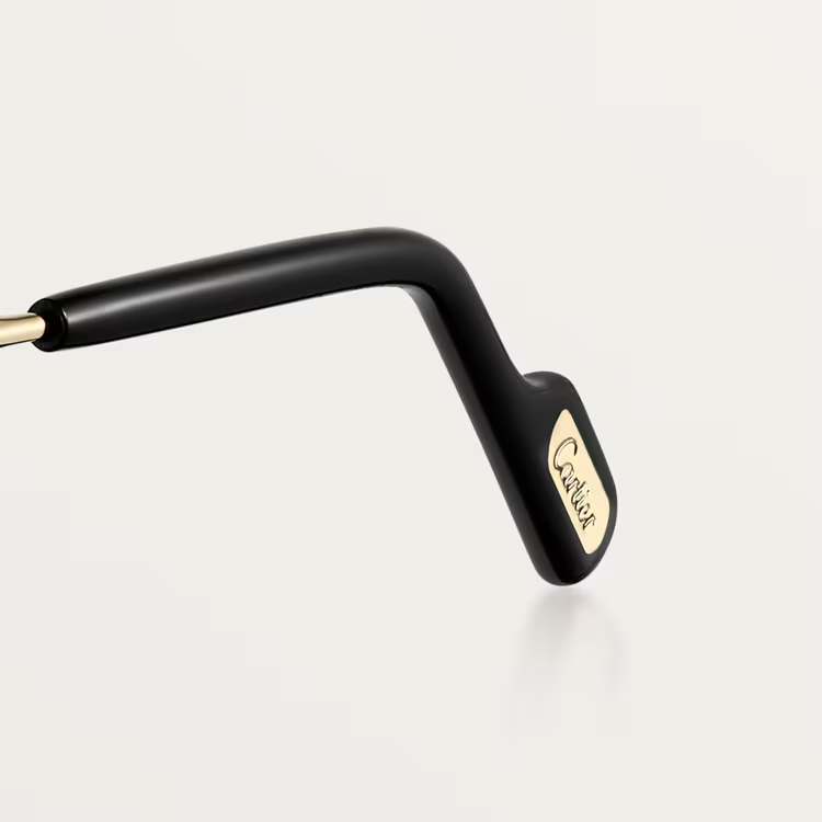 A close-up of the black temple with gold Cartier logo detail showcases the refined design of Cartier Sunglasses CT0550S-008 56, set against a plain light background.