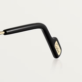 A close-up of the black temple with gold Cartier logo detail showcases the refined design of Cartier Sunglasses CT0550S-008 56, set against a plain light background.