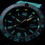A close-up of the Luminox Watches Pacific Diver Limited Edition 44 mm XS.3124.N.SET showcases this dive watch with Swiss Made precision, featuring glowing blue and green hour markers, a yellow minute hand, a turquoise strap, water resistance up to 200 meters, and a date window at 3 o’clock.