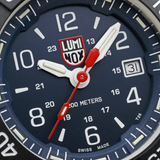 A close-up of the Luminox Watches Navy SEAL Rubber, Steel, CARBONOX™ (RSC) 45 mm (SKU: XS.3253.CB) by Luminox Watches showcases the time at 1:16:36, featuring bold white hour and minute hands, a vivid red second hand, and a date window at the 3 o’clock position. The watch face displays “200 METERS” and “SWISS MADE,” while its durable CARBONOX™ bezel highlights this Swiss Made dive watch’s rugged reputation for adventure.