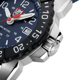 Close-up of the Luminox Watches Navy SEAL Rubber, Steel, CARBONOX™ (RSC) 45 mm (SKU: XS.3253.CB) showing part of the blue dial, black CARBONOX™ bezel with numerals, crown engraved with the Luminox logo, and a date window set to 31. The watch hands and hour markers stand out clearly on this Swiss Made dive watch from Luminox Watches.