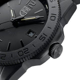 Close-up of a Luminox Watches Pacific Diver XS.3121.BO.1 wristwatch in black, highlighting the bezel, crown, partial watch face with date window, and the hour and minute hands. This Swiss Made dive watch from Luminox Watches is water resistant to 200 meters and features a rugged matte finish.