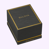 A black rectangular box with gold trim containing a Bulova 98A177 Maquina Automatic Black Silicone Strap Men Watch, with the brand name printed on the lid and side.