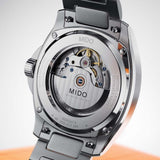 Close-up of the stainless steel case back of a Mido Watches Multifort TV Big Date Chronometer M0495671104100, showing the COSC-certified movement through a circular sapphire crystal exhibition window.