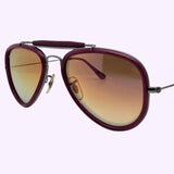 The Ray-Ban 0RB3428 004/70 Unisex Sunglass by Ray-Ban Sunglasses features aviator-style frames in a dark red hue, a padded top bar, gradient brown lenses, and slim metal arms—exuding the timeless appeal of the iconic RB3428 design. Displayed against a light purple background for a modern touch.