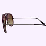 Side view of the Ray-Ban 0RB3428 004/70 Unisex Sunglass by Ray-Ban Sunglasses, featuring thin metal arms, brown-tinted lenses, and dark purple frames, set against a light background.