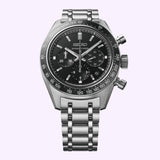 A Seiko Watches Prospex Speedtimer Mechanical Chronograph SRQ055 by Seiko Luxe Watches, featuring a stainless steel band, black dial with three sub-dials, and silver hour markers, is displayed against a light purple background.