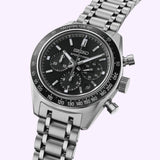 A Seiko Watches Prospex Speedtimer Mechanical Chronograph SRQ055 by Seiko Luxe Watches, featuring a stainless steel case, black chronograph dial with silver markers, and a tachymeter bezel, displayed on a light background.