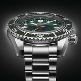 Close-up of Seiko SPB381 green gradient dial with gold GMT hand, 24-hour flange, and LumiBrite markers