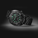 The Seiko Watches The Black Series Prospex Sea SRPK43 by Seiko Luxe Watches features a sleek metal band, luminous green hour markers and hands, and a clear day-date display—all set against a dark gradient background—a striking demonstration of Japanese watchmaking expertise.