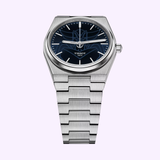 The TISSOT Watches PRX UFO Robot Grendizer T1374071104102 is a limited edition stainless steel wristwatch with a geometric-link bracelet, dark blue dial, silver hour markers, and the Tissot 1853 logo.