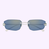 Cartier Sunglasses CT0474S-005 UNISEX feature rimless rectangular blue-tinted lenses, thin silver bridge and arms, and green and white hinge accents, shown on a pale lavender background.