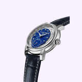 The Frederique Constant Manufacture Worldtimer FC-718LA4H6 luxury watch features a blue marbled Lapis Lazuli dial, silver casing, world time markers, and a black leather strap with white stitching against a light purple background.