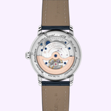 The transparent case back of the Frederique Constant Manufacture Worldtimer FC-718LA4H6 reveals intricate gears, while a stitched brown leather strap and engraved details complete this Swiss luxury timepiece.