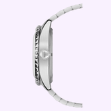 Side view of the Mido Watches OCEAN STAR GMT M0268291804100, featuring a silver metal band, ridged bezel, and logo-engraved crown—automatic movement displayed against a pale lavender background.