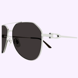A close-up of Cartier CT0364S-001 59 Unisex Sunglasses by Cartier Sunglasses, featuring dark lenses, silver metal frames, and unique side detail on a light purple background—ideal for standout luxury eyewear style.
