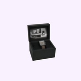 A square Bulova Watches 96A314 Ennis House with a brown leather strap rests in an open black box. The lid features a black and white image inspired by the iconic modernist Ennis House design.