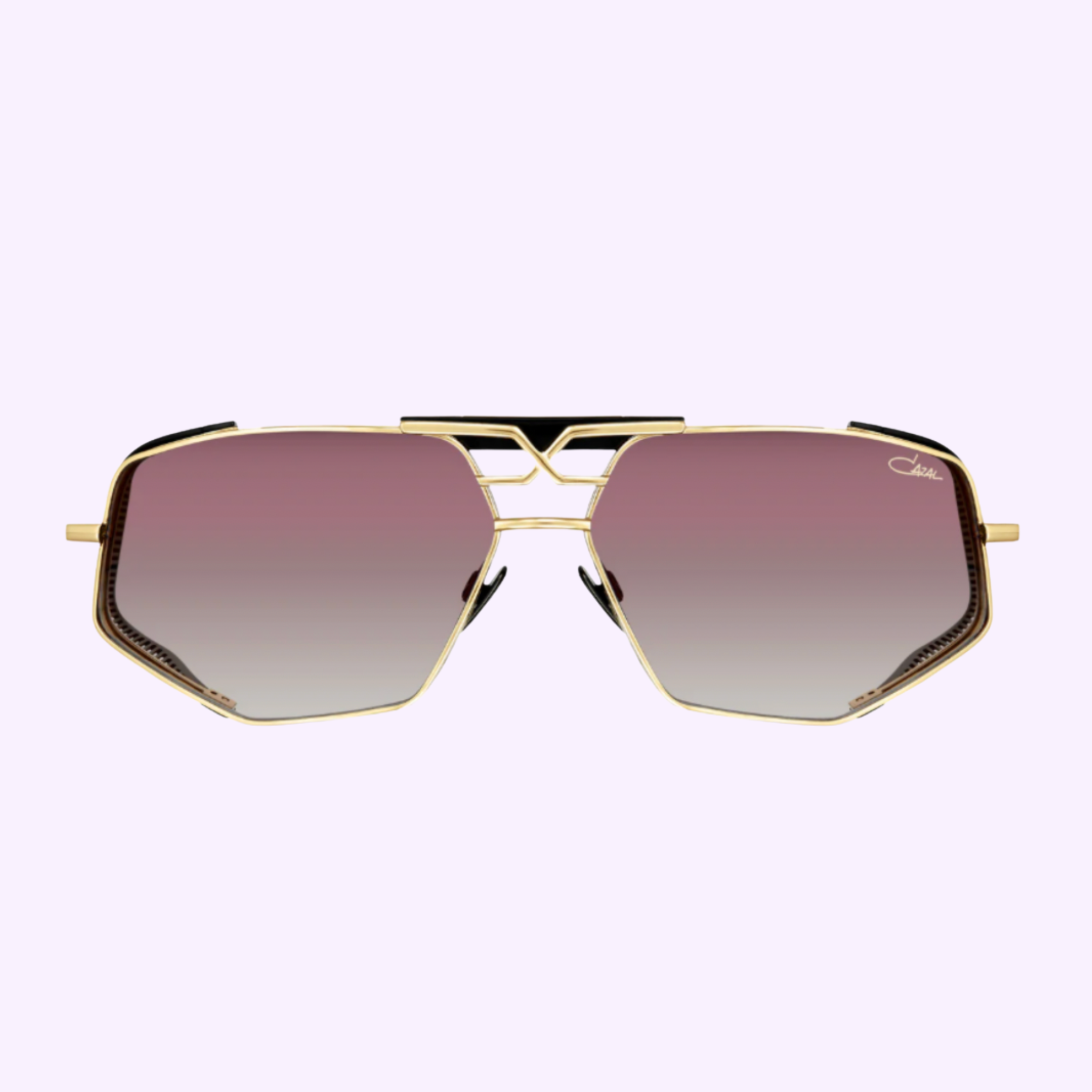 Cazal Sunglasses MOD 050 Anniversary Edition Gold-Black 001 featuring angular gold frames and pink-to-clear gradient lenses, shown on a light purple background.