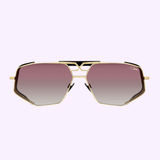 Cazal Sunglasses MOD 050 Anniversary Edition Gold-Black 001 featuring angular gold frames and pink-to-clear gradient lenses, shown on a light purple background.