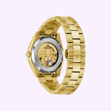 The Bulova Watches Surveyor 97A182 Men’s wristwatch is shown from the back, displaying its automatic 21-jewel movement through a transparent case back and a gold-tone stainless steel bracelet with polished links.