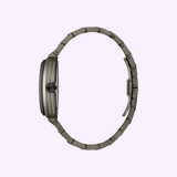 A side view of the Bulova Watches Bulova Maquina 98A321, a sleek wristwatch with a metallic band and round face, displayed against a light purple background. The thin automatic watch features an elegant ridged texture on its face.