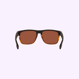 A pair of rectangular Costa Del Mar Sunglasses 900818 Spearo Matte Black with polarized dark brown glass lenses and sleek matte black and tortoiseshell frames, displayed against a pale lavender background, front view.