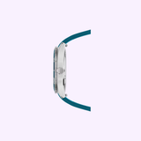 Side view of the 39mm Mido Watches Ocean Star 39 M0269071104101 with a silver case, textured crown, and teal strap on a light purple background, highlighting its sleek Swiss automatic design.