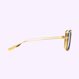 A side view of Dita Sunglasses DUBSIGNAL DTS465-A-01 Unisex (UPC 0810121956700) with a gold metal frame, thin double-layered temple arms, and dark-tinted lenses, set against a light purple background.