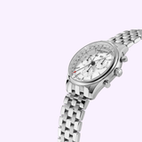 The Frederique Constant Classics Quartz Chronograph Triple Calendar FC-296SW5B6B wristwatch, featuring a silver metal link band, three subdials, and a date window, is displayed at an angle against a light lavender background.