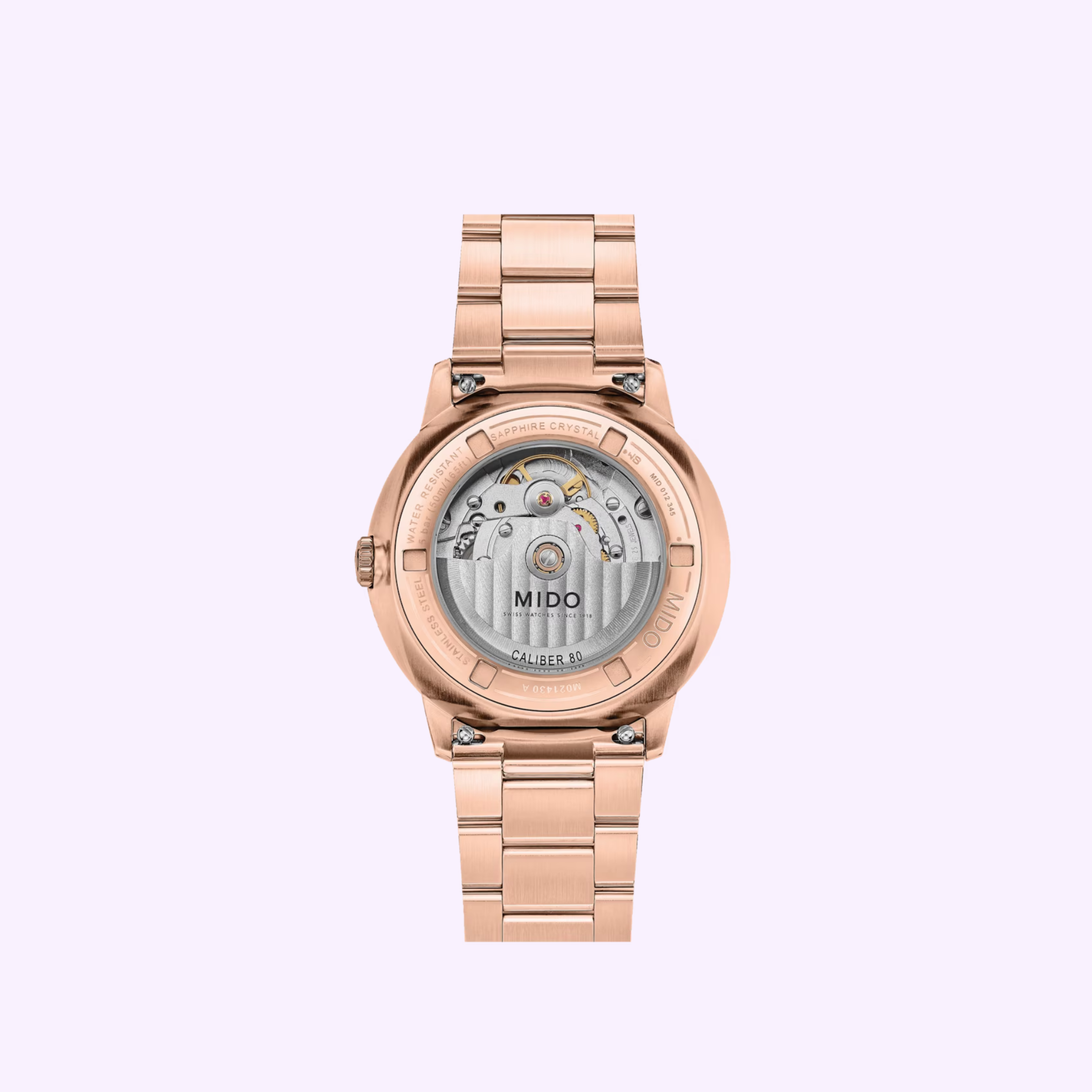 The Mido Watch Commander Datoday M0214303309100 by Mido Watches features a rose gold automatic design with a visible mechanical movement and transparent sapphire case back, displayed on a light purple background.