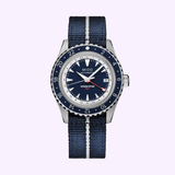 The Mido Watches OCEAN STAR GMT M0268291804100 features a blue dial, silver bezel, and blue-striped fabric strap, with white markers and hands, a date window at 3 o’clock, and bold red GMT text—a Swiss-made dive watch by Mido.